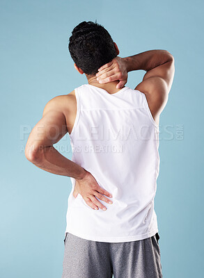 Buy stock photo Back pain, injury and man in studio, inflammation and aching body on blue background. Person, model and guy with stress, massage and bruise with muscle tension, strain and pressure on joints