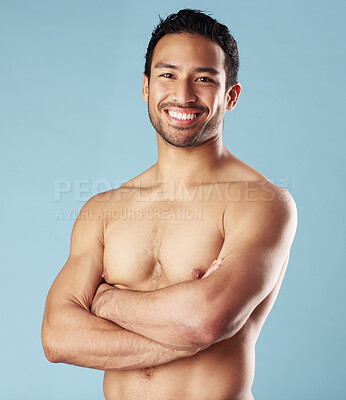 Buy stock photo Man, fitness and arms crossed with muscle in studio, smile and pride for body transformation by blue background. Asian person, bodybuilder and portrait with growth, strong and shirtless in Indonesia