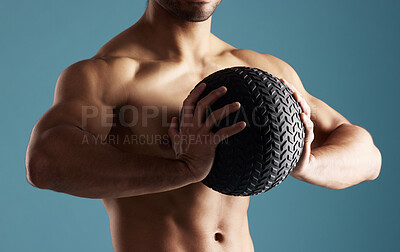 Buy stock photo Fitness, hands and man with medicine ball for training, exercise or workout for health. Muscle, shirtless and strong bodybuilder with equipment for growth, weight and power on blue studio background