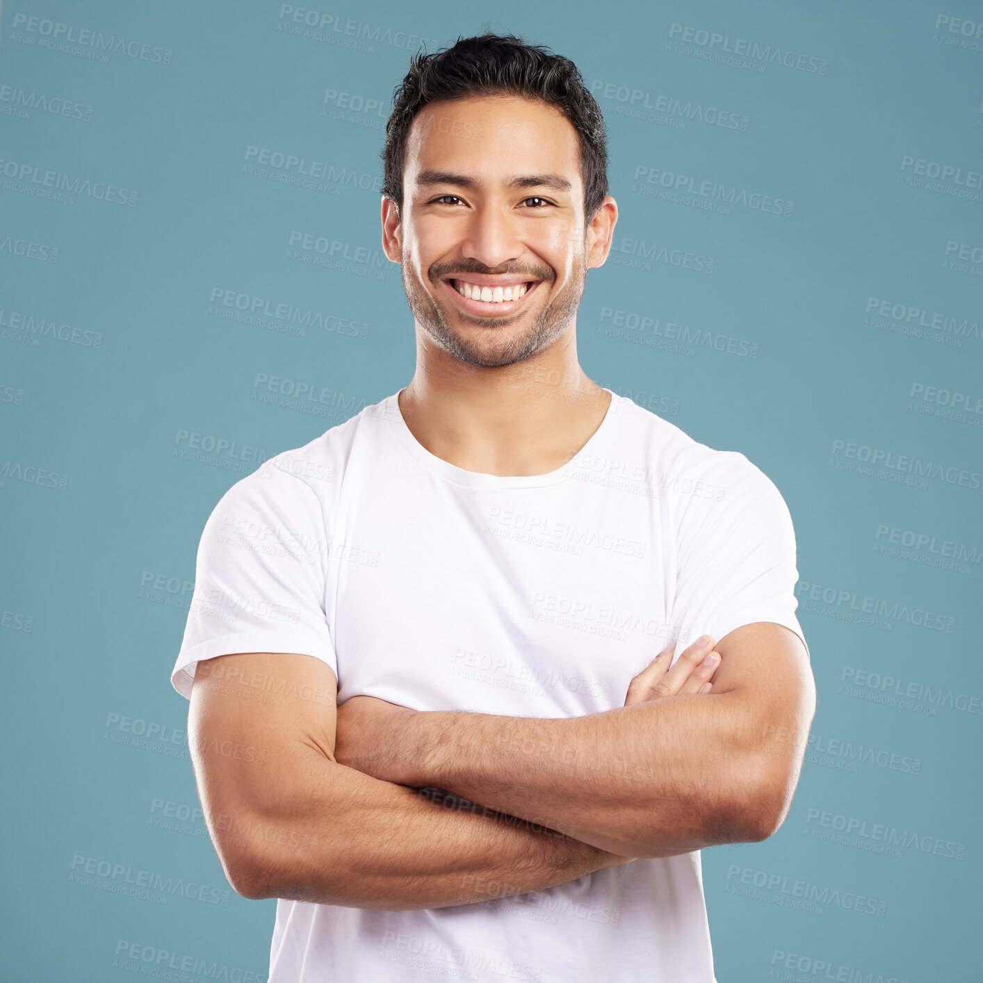Buy stock photo Portrait, happy and confident man with arms crossed with smile in studio for casual fashion or clothes. Aesthetic, satisfied or friendly handsome person on blue background with pride, joy and space