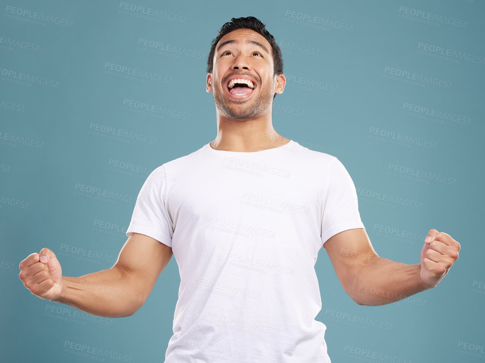 Buy stock photo Goals, man and excited in studio with fist pump, celebration and achievement for winning prize. Hand gesture, male person and winner with cheering for bonus, discount or yes scream by blue background