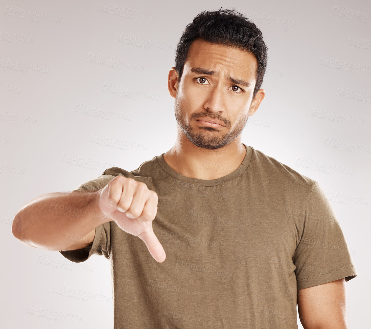 Buy stock photo Portrait, sad and man with thumbs down in studio for fail, bad review and wrong on white background. Hand gesture, dislike and sign for negative feedback, rejection emoji and disapproval of opinion
