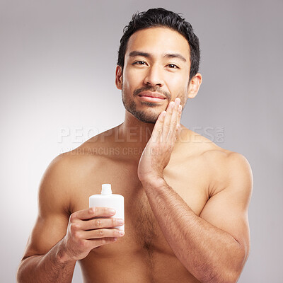 Buy stock photo Beauty, lotion and portrait of man in studio to apply cream for cosmetics or dermatology. Aesthetic, moisturizer and skincare with shirtless model on gray background for cosmetology or satisfaction