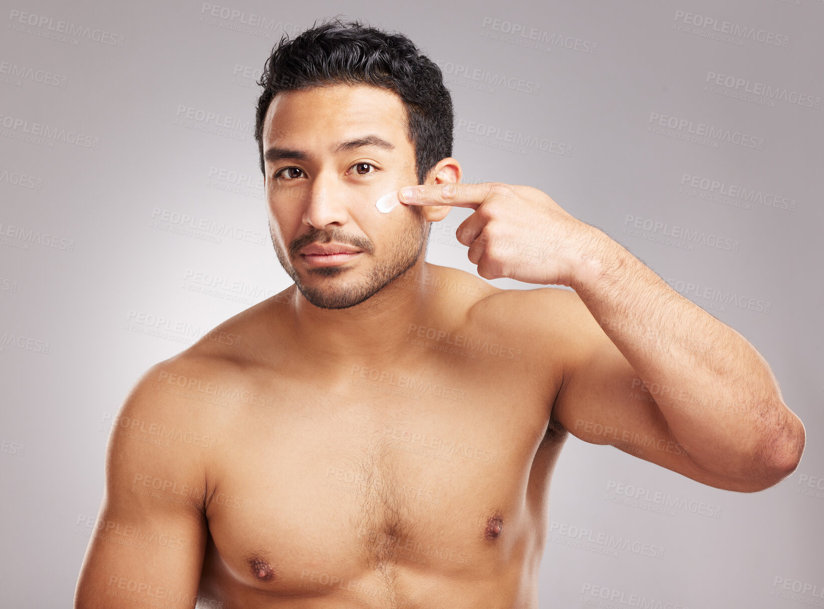Buy stock photo Beauty, moisturizer and portrait of man in studio to apply lotion for cosmetics or dermatology routine. Aesthetic, cream and skincare with shirtless model on gray background for antiaging cosmetology
