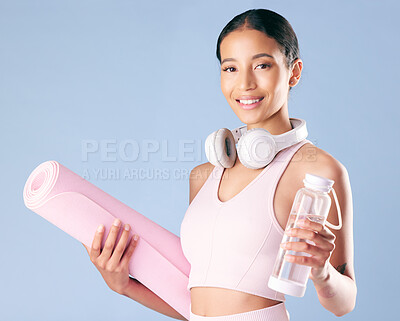 Buy stock photo Fitness, woman and water with yoga mat in studio for training hydration, workout break or headphones. Health portrait, wellness or athlete with smile for pilates, exercise or space on blue background