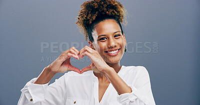 Buy stock photo Hands in heart, studio and portrait of happy woman with gesture for support, kindness or care. Smile, confident and person with emoji, sign and hope for thank you, charity and love on blue background