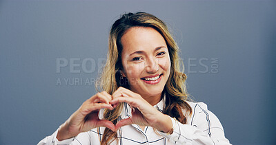 Buy stock photo Happy, portrait and woman with heart hands in studio for appreciation, kindness and thank you. Space, person and love gesture on gray background for support, gratitude and motivation sign with smile