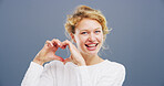 Hands in heart, happy and portrait of woman with gesture for support, kindness and care. Studio space, confident and person with emoji, sign and hope for thank you, charity or love on blue background