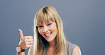 Thumbs up, smile and hands with portrait of woman in studio for approval, success or feedback. Like emoji, yes sign and agreement with female person on background for vote, symbol and promotion icon 