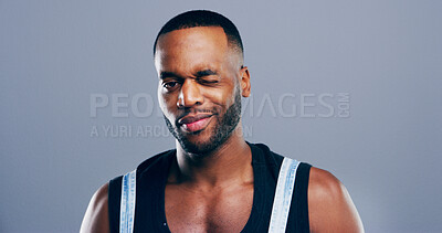 Buy stock photo Portrait, wink and black man in studio, fitness and support on blue background. African person, bodybuilder and athlete with expression, motivation for training and greeting with gesture or thank you