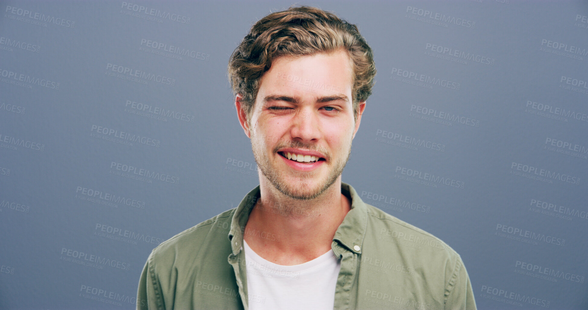 Buy stock photo Wink, smile and flirt with portrait of man in studio for secret, agreement and support gesture. Happiness, rumour and gossip with person on background for discount review, space and well done sign