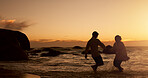 Playful, couple and water by sunset on beach, vacation holiday and bonding together for anniversary. Ocean, man and woman with holding hands for love, travel adventure and connection in relationship