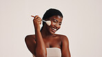 Brush, happy and black woman in studio with makeup, beauty or cosmetics for getting ready. Smile, cosmetology and African female person with blush for facial color or glow by white background.