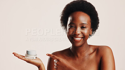 Buy stock photo Happy, black woman and portrait with lotion in studio for hydration, treatment and sunscreen protection. Person, pointing and advertising cream for facial dermatology, anti aging and white background