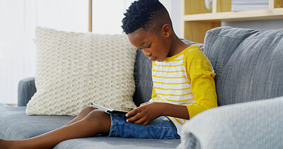 Buy stock photo Tablet, home and child relax for reading ebook, learning app or streaming cartoon on sofa. African boy, kid and online in living room on technology to scroll entertainment, watch movies or play games