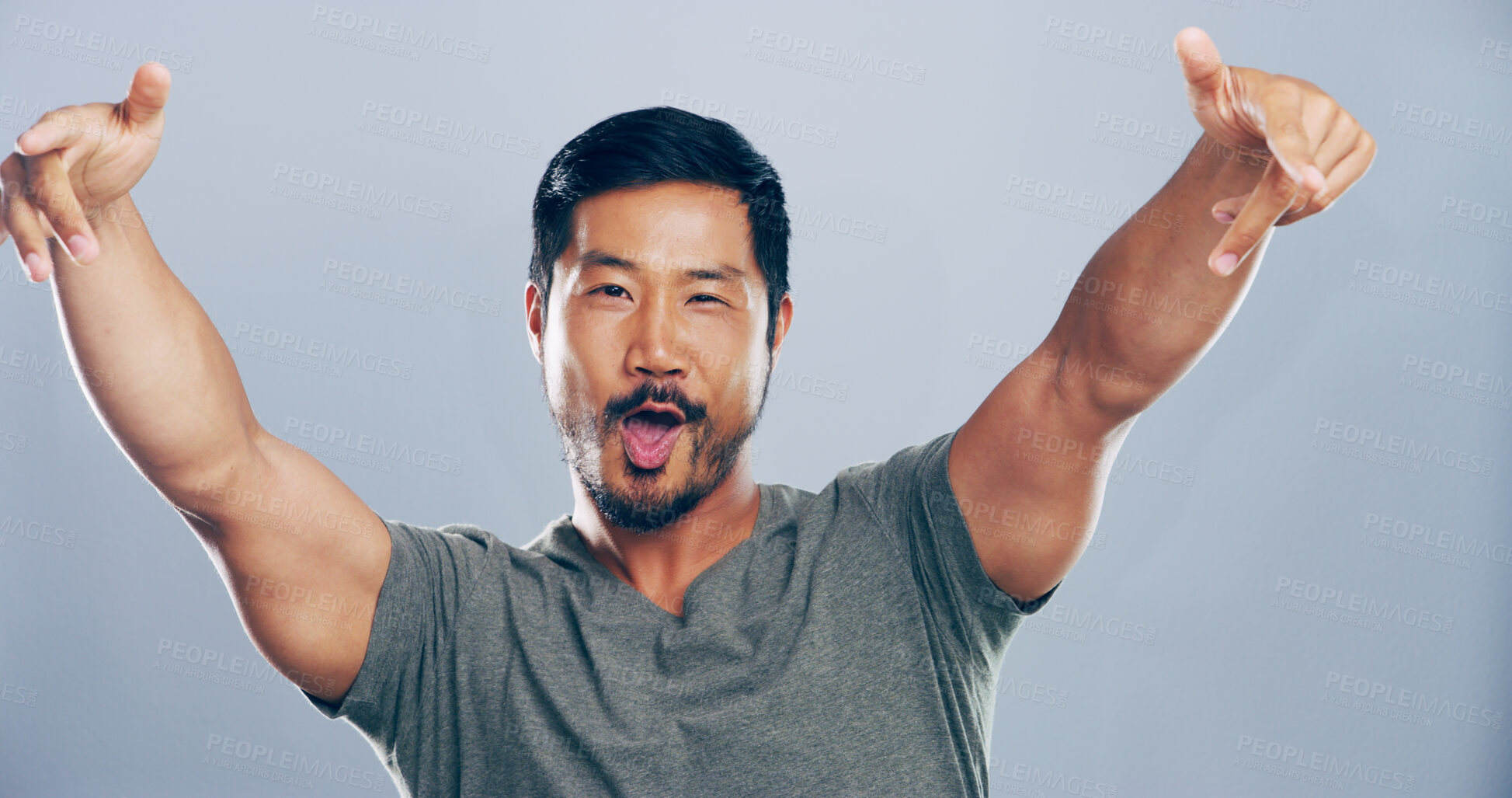 Buy stock photo Portrait, cheering and man in studio, sign and celebration with confidence on gray background. Asian person, pride and model with symbol, icon and happiness with support, success and achievement