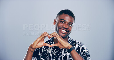 Buy stock photo Heart hands, portrait and smile with black man in studio for affection, love or romance. Emoji, happy and social media with flirty person on gray background mockup for health or wellness gesture