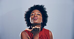 Pout, woman and blowing kiss in studio, flirting and gesture for romance for valentines day or space. Blue background, mockup and black person with expression for love, happy and portrait of girl