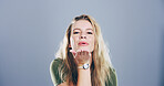 Flirting, woman and blowing kiss in studio, portrait and gesture for romance for valentines day or space. Blue background, mockup and person with expression for love, happy and girl with pout in USA