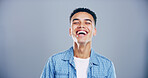 Face, man and happy for laugh in studio with confidence, joke and good mood on gray background. Space, young model and smile with carefree personality for comedy, humor or funny reaction to meme