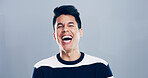Comic, man and portrait for laugh in studio with confidence, joke or good mood on gray background. Space, excited model and smile with carefree personality for comedy, humor or funny reaction to meme