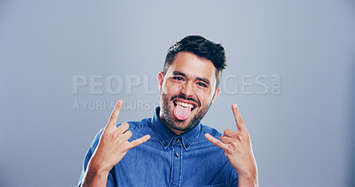 Buy stock photo Space, happy or portrait of man with rock hand gesture in studio for wild expression on gray background. Culture, edgy male rocker and crazy person with devil horn sign, funky emoji and punk symbol