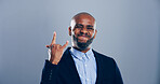 Studio, portrait and black man with rock hand gesture and tongue out isolated on gray background. Space, edgy rocker and African male person with devil horn sign, funky emoji and wild punk symbol