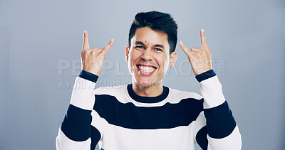 Buy stock photo Rock, emoji and portrait of man in studio with hand gesture for crazy, heavy metal and edgy attitude. Mockup space, happy and face of person with punk sign, symbol and devil horns on gray background