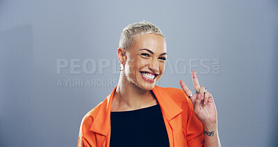 Buy stock photo Portrait, peace sign and woman with smile, icon and confidence on blue studio background. Face, happy person and model with hand gesture, support and agreement with symbol, good vibes and emoji