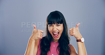 Buy stock photo Girl, portrait and excited with thumbs up in studio for vote success, winning achievement or support. Space, woman or happy feedback with yes gesture for positive review or opinion on blue background