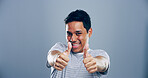 Man, portrait and positive with thumbs up in studio for winner announcement, support or poll agreement. Mockup, person and happy feedback with like gesture for motivation or praise on gray background