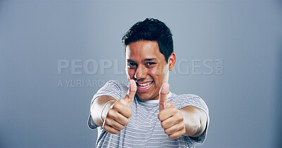Buy stock photo Man, portrait and positive with thumbs up in studio for winner announcement, support or poll agreement. Mockup, person and happy feedback with like gesture for motivation or praise on gray background
