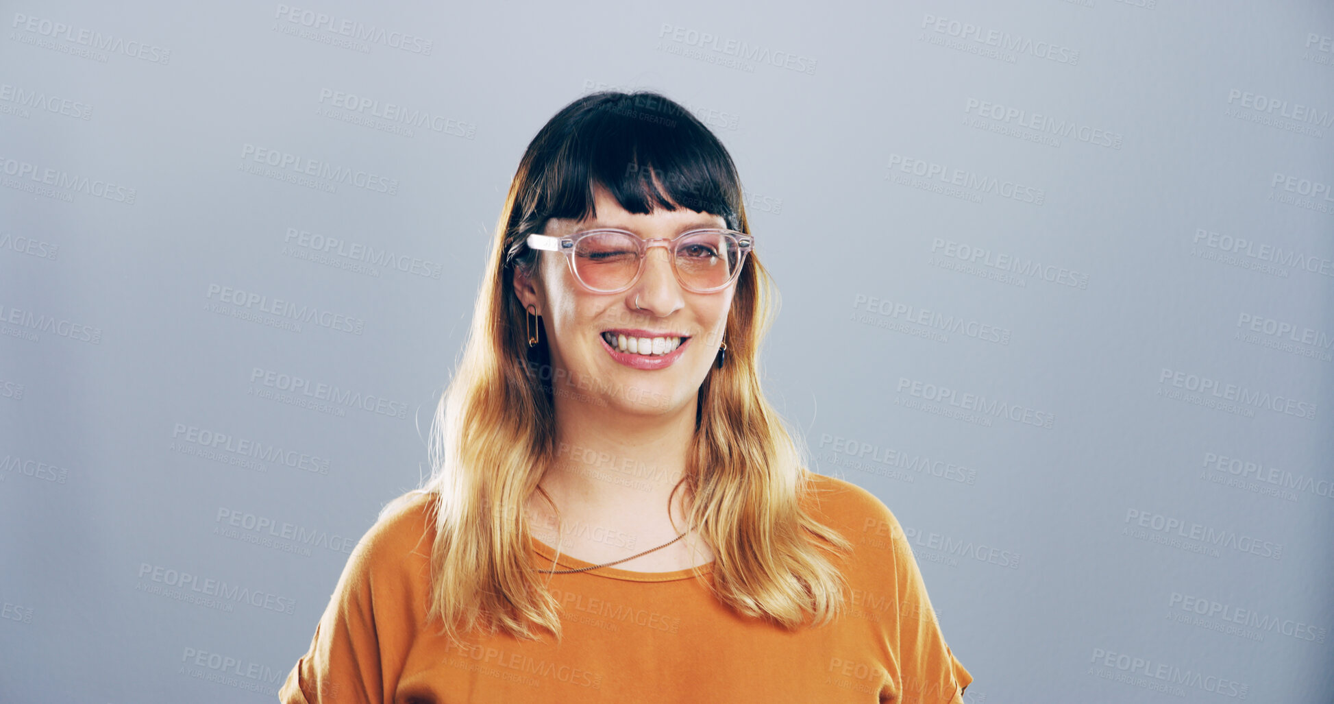 Buy stock photo Woman, wink and sunglasses with smile in studio, emoji and flirt with eye symbol by background. Person, model and happy with icon, portrait and secret with trendy fashion, deal and space in USA