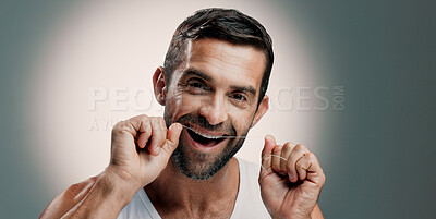 Buy stock photo Teeth, happy and man in portrait with dental floss for oral hygiene, plaque removal and gum health. Mockup space, person and mouth care on studio background for fresh breath and cavity prevention