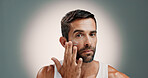 Beauty, face cream and portrait of man in studio for wellness, health and hydration for facial treatment. Dermatology, skincare and person with lotion, moisturizer or cosmetics on gradient background