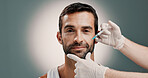 Hands, injection and plastic surgery with portrait of man in studio for change or transformation. Collagen, face and syringe of doctor with patient on gray background for cosmetic surgery or facelift