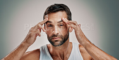 Buy stock photo Model, face check and portrait in studio for skincare, wellness or cosmetics with space for antiaging. Male person, man and inspection for wrinkles, beauty treatment or routine on gray background