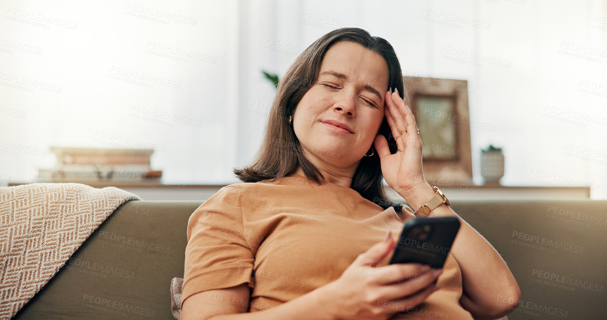 Buy stock photo Pain, sofa and woman with smartphone, headache and communication for sickness with mobile or telehealth. Stress, thinking and person with migraine in house, lounge and research with tech for illness
