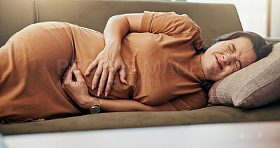 Buy stock photo Tired, pregnancy and woman on sofa with pain, cramps and contractions for rest in living room. Parenting, maternity health and pregnant person on couch for discomfort, prenatal stress or hurt in home