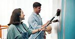 Couple, project and painting a wall in home for diy renovation, living room makeover or house improvement. Interior design, people or support for decoration process, conversation or relationship