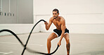 Fitness, man and battle ropes outdoor for core strength workout, power training and muscular endurance. Athlete, person and energy with exercise equipment for agility, health performance or challenge