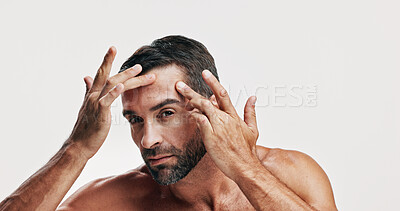 Buy stock photo Studio, portrait and man check skincare for dermatology routine, self care or glow on white background. Natural, facial treatment and male model with cosmetics, face inspection or grooming for beauty
