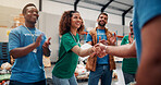 Clapping, handshake and support with volunteer team in warehouse together for aid, community or welfare. Applause, charity and donation with people shaking hands for ngo or non profit success