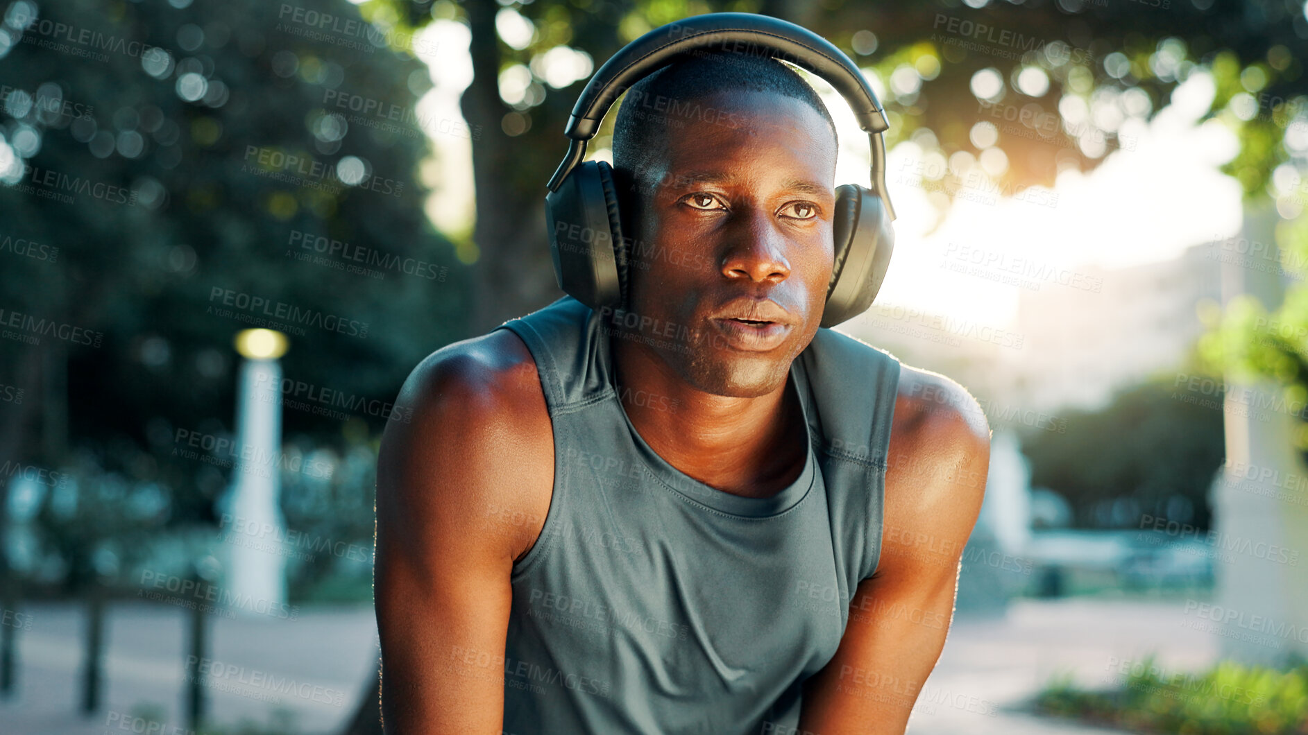 Buy stock photo Fitness, tired and black man with headphones in nature for workout podcast, running challenge and breathing break. Athlete, runner or relax at park with exercise playlist, sweat and marathon recovery