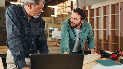 Buy stock photo Carpentry, talking and men on laptop in workshop for woodwork, furniture restoration and lumber manufacturing. Construction, computer and people planning with planks, timber and board for renovation