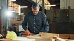 Industry, measuring tape and wood with carpenter man in workshop for manufacturing or production. Carpentry, construction and maintenance with mature contractor at work for professional renovation