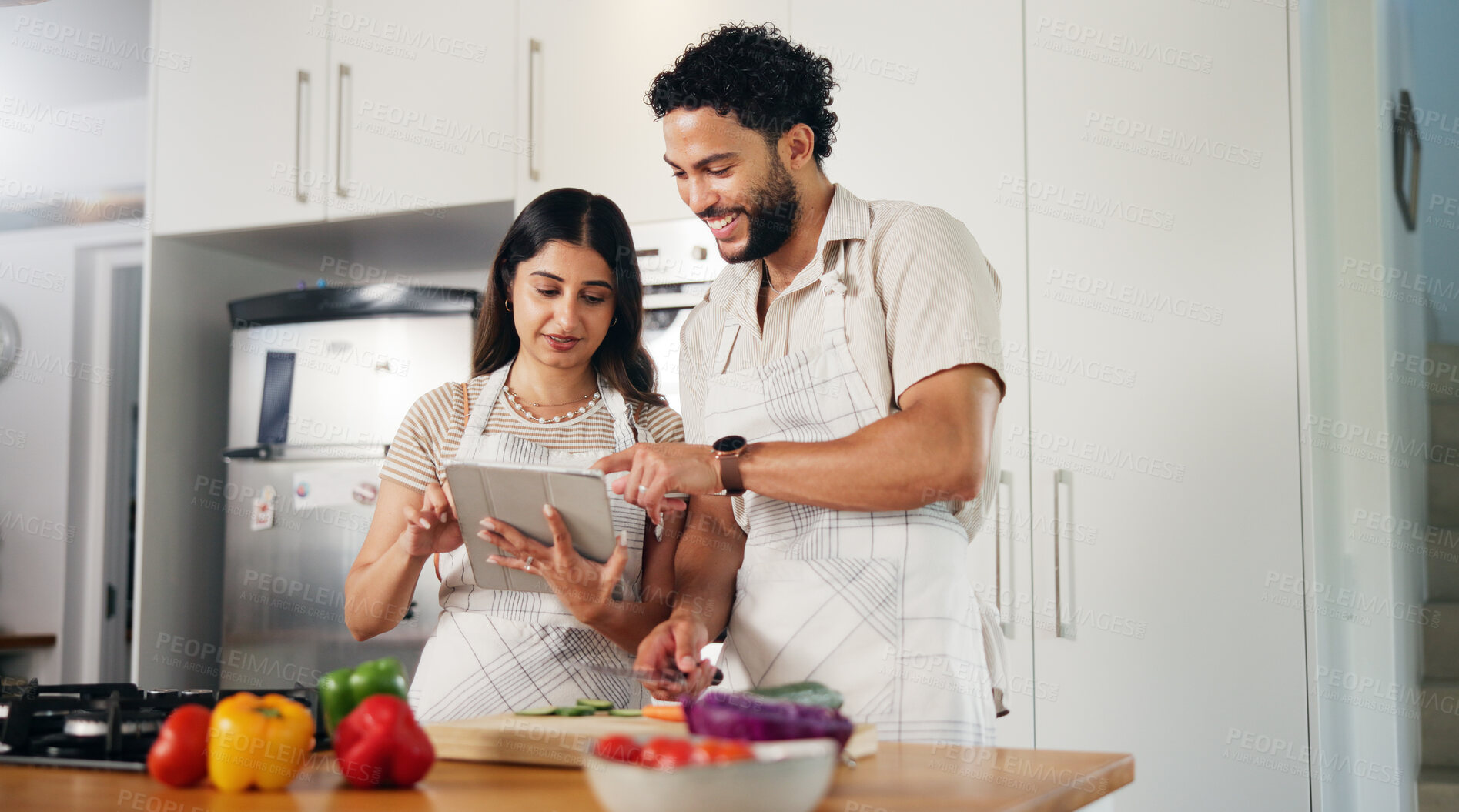 Buy stock photo Couple, happy and cooking with tablet in kitchen for online recipe, meal prep or watching web tutorial. People, food blog and vegetable ingredients for healthy salad, diet planning or support in home