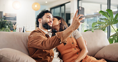 Buy stock photo Selfie, kiss and couple in home, relax and post for memory in social media, bonding and chilling. Embrace, man and woman with picture, photography and break in living room with spouse, love or house