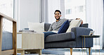 Happy man, relax and weekend with sofa for morning, comfort or peace in living room at home. Male person, holiday or sitting with cheerful smile in joy on couch for calm day, break or rest at house