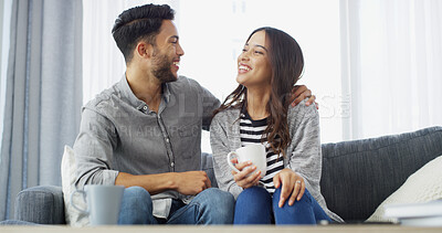 Buy stock photo Happy, laugh and couple with coffee on sofa for conversation, bonding and relax together. Home, dating and man hug woman with drink for relationship, affection and embrace for love in living room